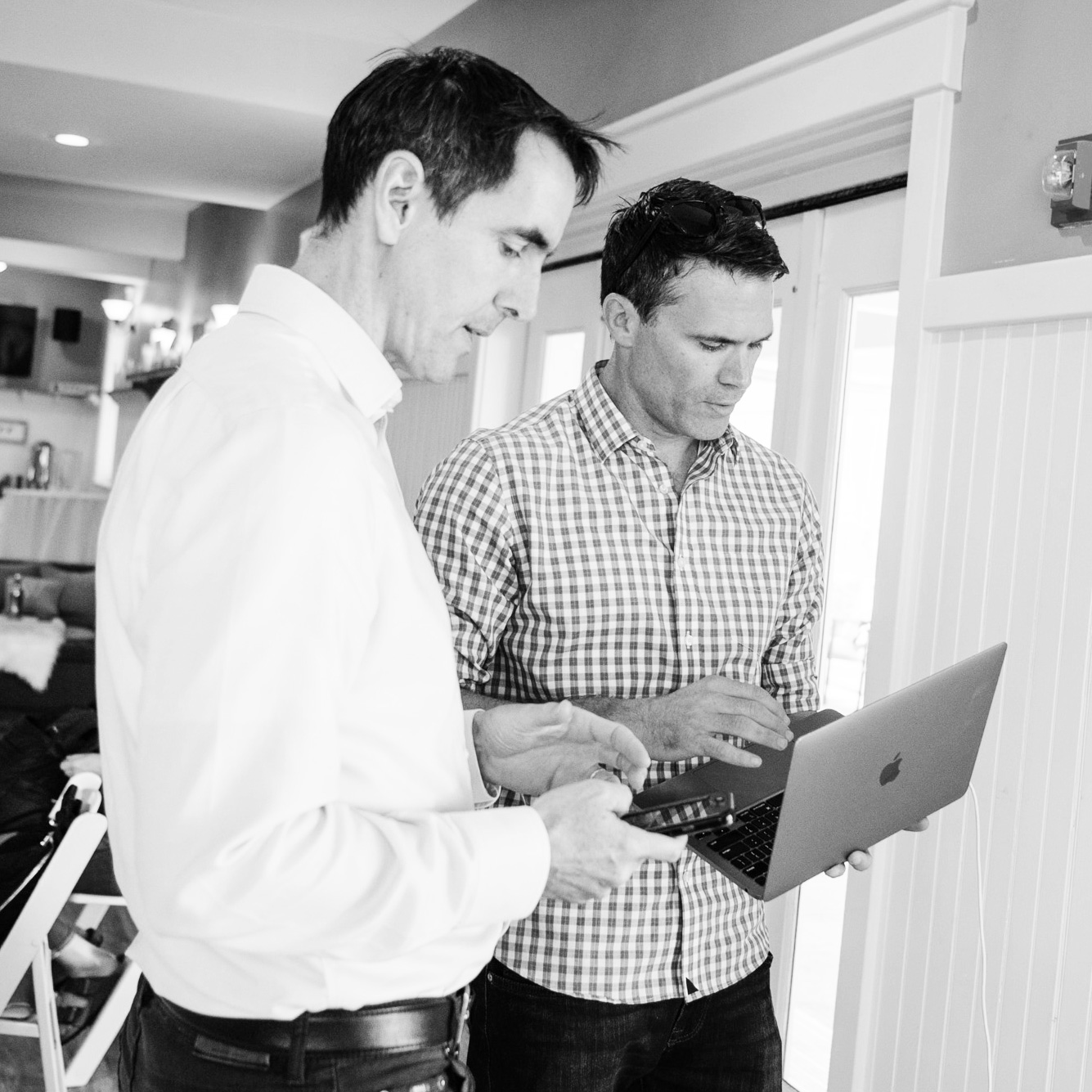 Two Building Impact Partners colleagues reviewing work together on a laptop